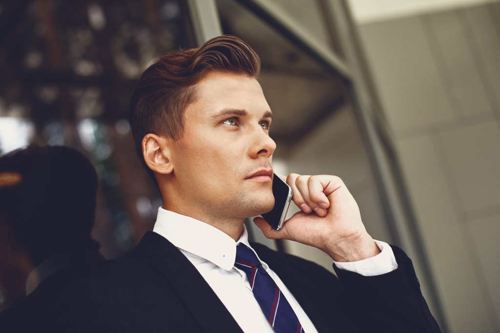 A calm man looking blankly while talking over the phone