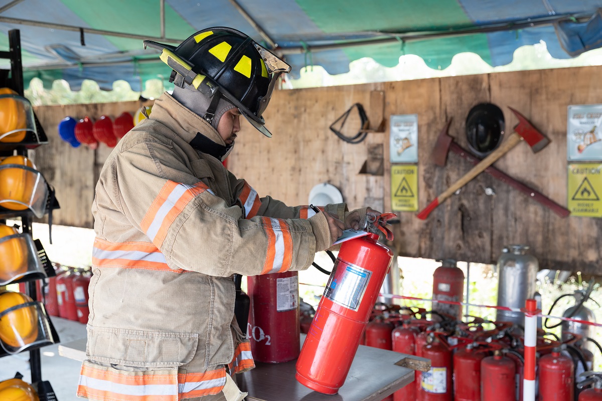 A fireman checking fire extinguishers